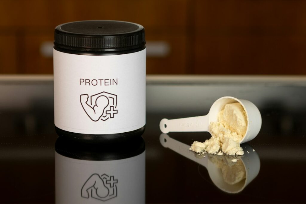 A generic protein powder container and scoop; illustrative stock photo